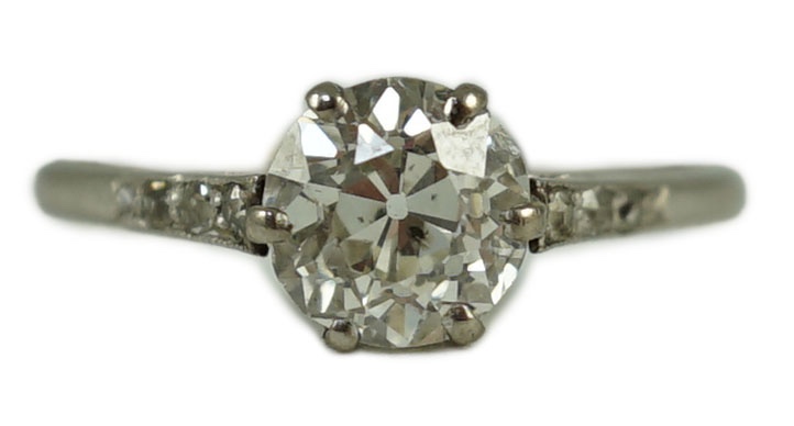 A platinum and single stone diamond ring, with diamond chip set shoulders